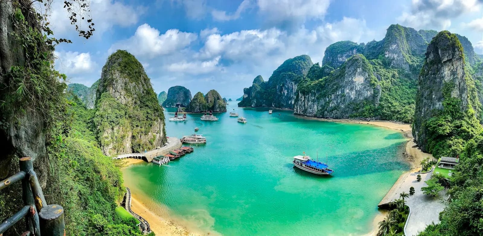 Boats on turquoise water between limestone islands in Ha Long Bay