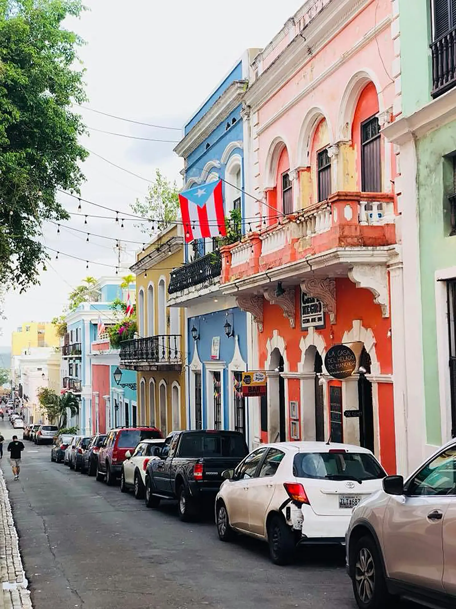 Pastel colonial buildings and a Puerto Rican flag on a street in Old San Juan