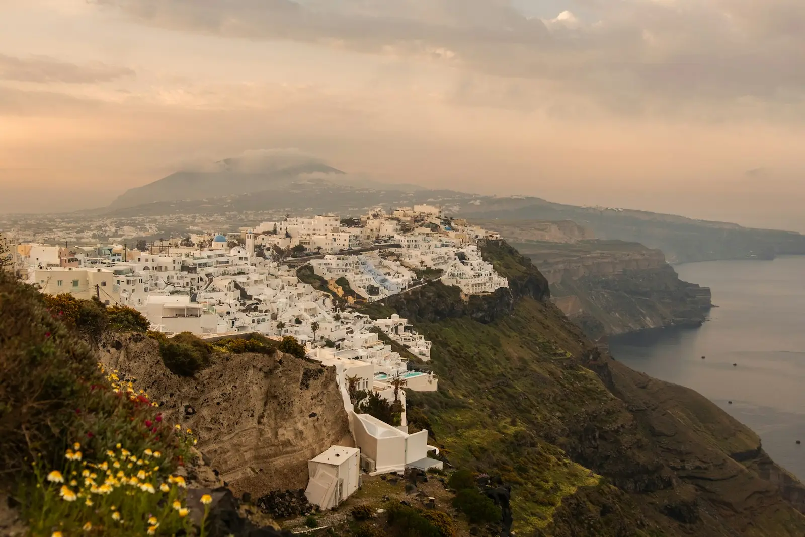 Casas blancas al borde de los acantilados de la caldera de Santorini al atardecer