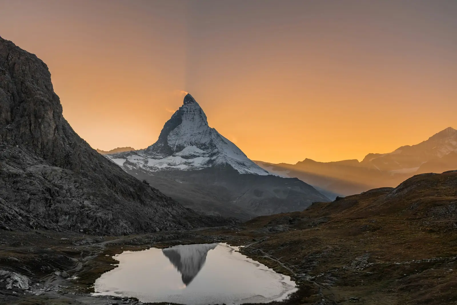 The Matterhorn reflected in a small alpine lake at sunset
