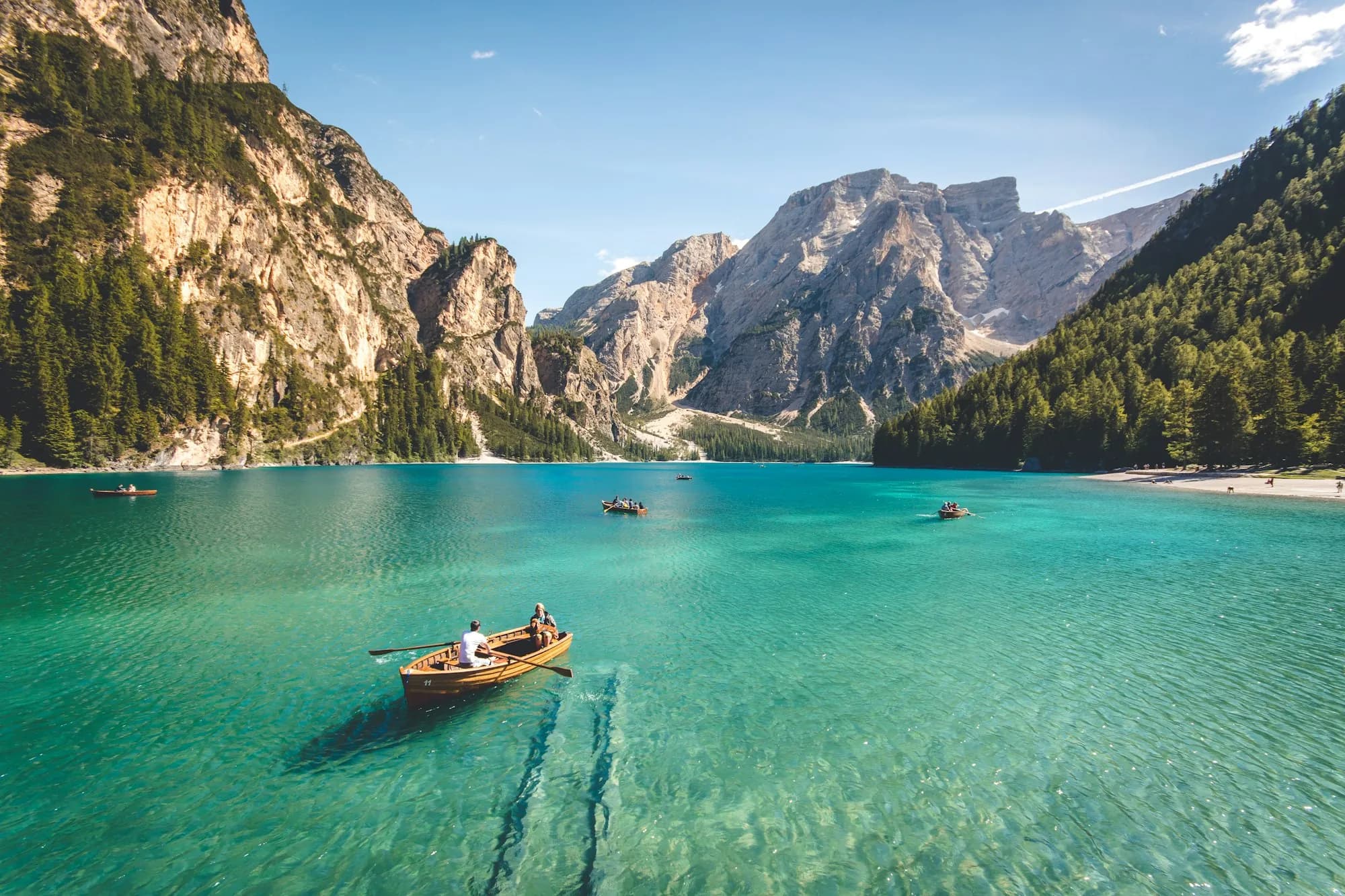 A rowboat on the turquoise water of Lago di Braies, below the Dolomites