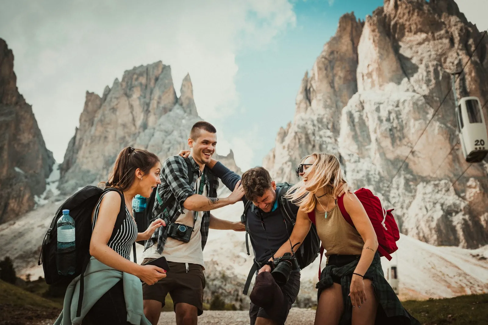 Four friends laughing on a mountain trail