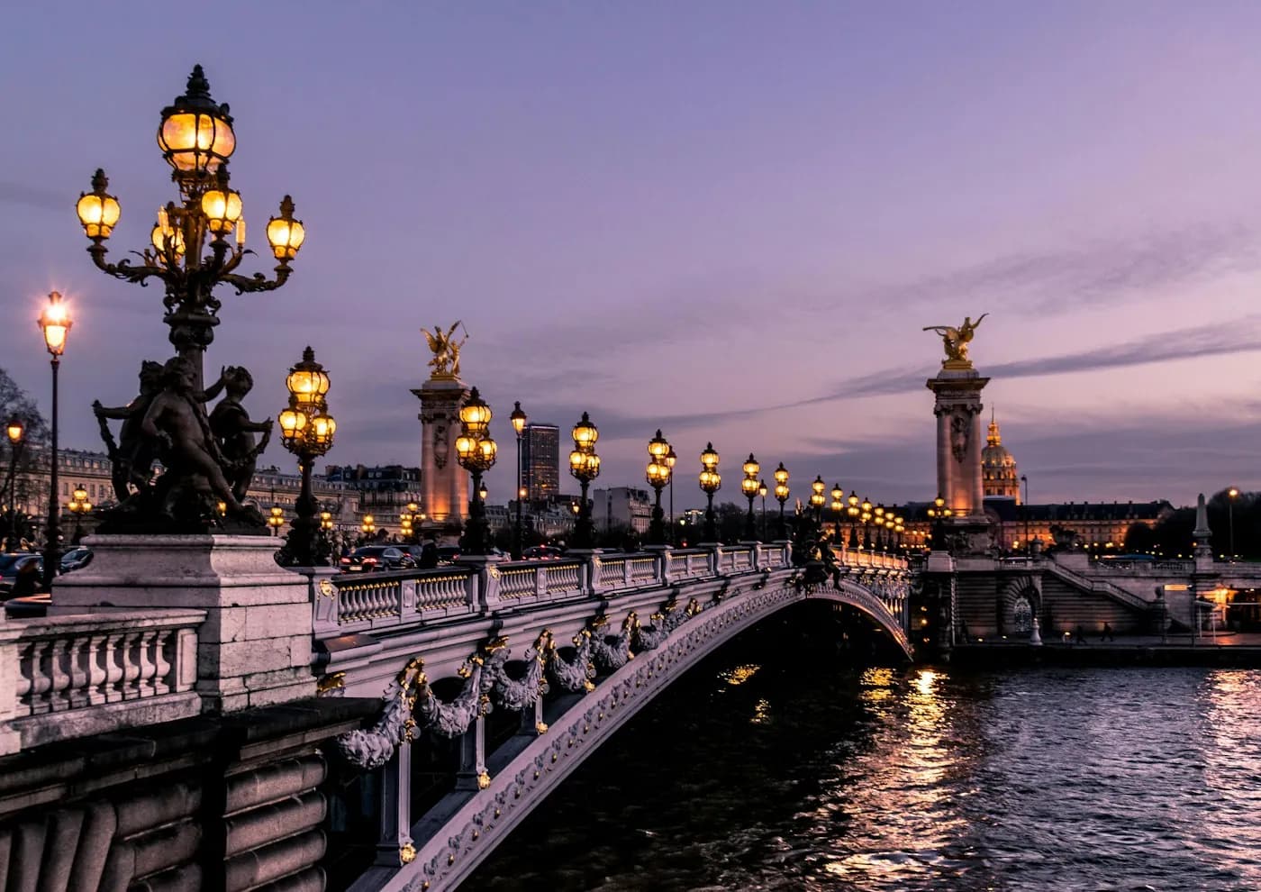 Faroles encendidos sobre un puente del Sena en París al anochecer
