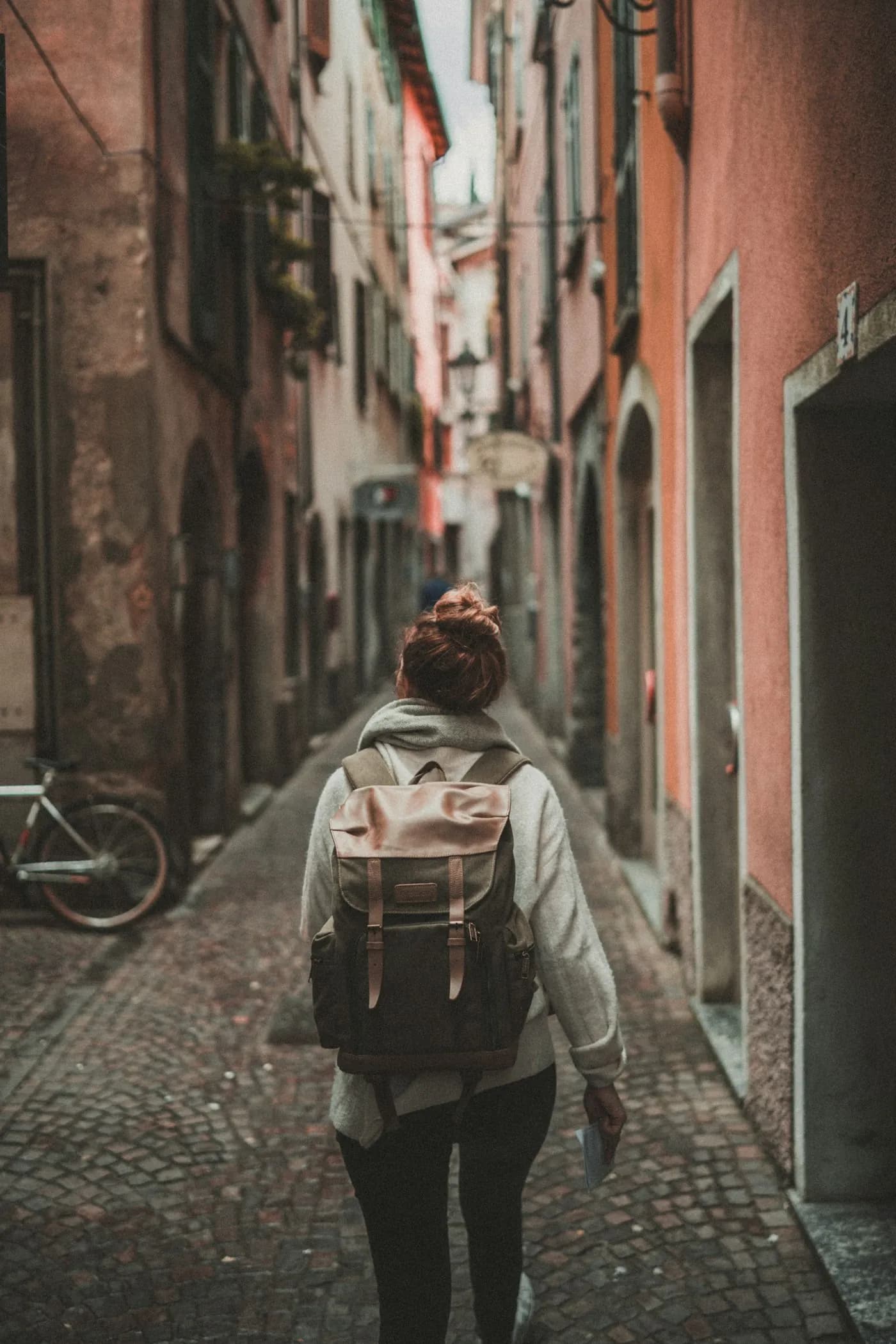 Una viajera con mochila caminando por una calle angosta del casco antiguo